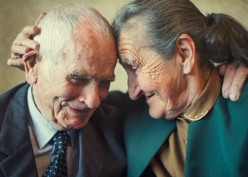 cute 80 plus year old married couple posing for a portrait in their house love forever concept