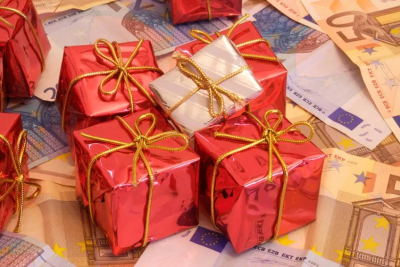 cadeaux de noël sur un tas d'argent (billets d'euros) qui représente combien d'argent important est dans la société de consommation d'aujourd'hui, surtout quand noël vient