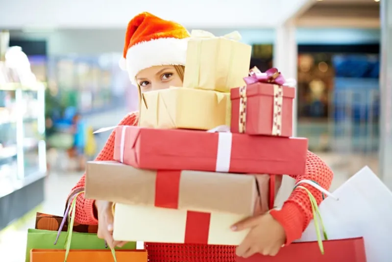 jeune femme avec des tas de cadeaux de noël