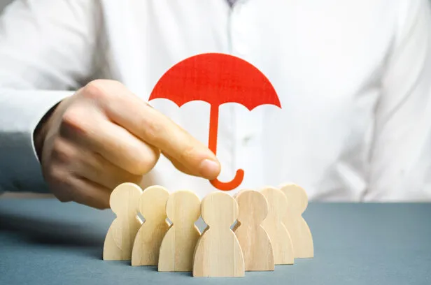 boss holding a red umbrella and defending his team with a gesture of protection life insurance customer care, care for employees security and safety in a business team selective focus