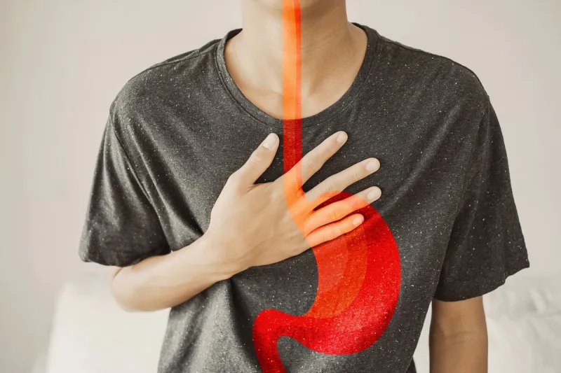 young man having heartburn, gastroesophageal reflux disease (gerd) or acid reflux symptom, health care concept