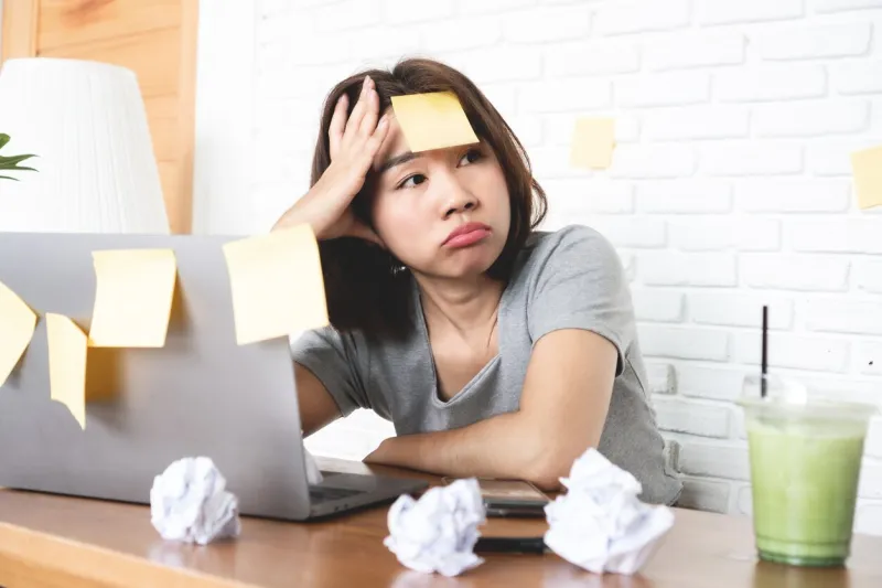 stressed female worker burnout at workplace , bored asian business woman less motivated to work