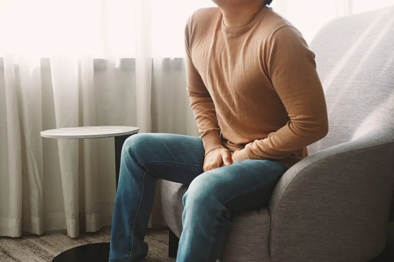 man using his hands touching and covering his crotch suffering f