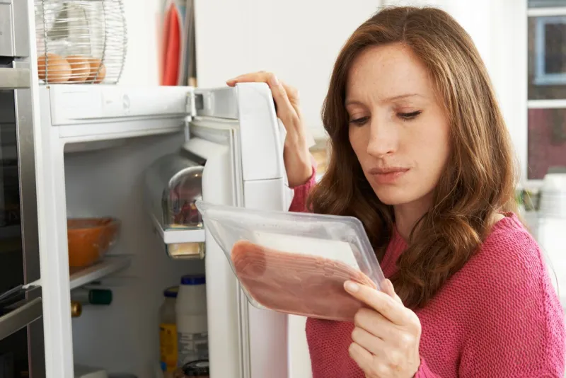 concerned woman looking at pre packaged meat