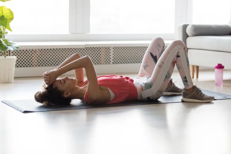 millennial tired sporty woman wearing activewear lying on sports mat resting after training active workout at home, take break pause, refreshment moment, healthy lifestyle, ending of training concept