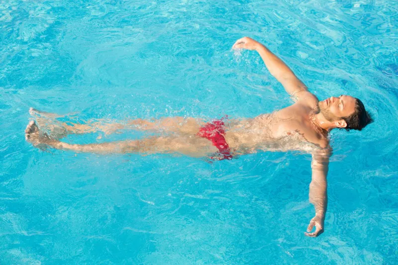 beautiful man swimming in the pool