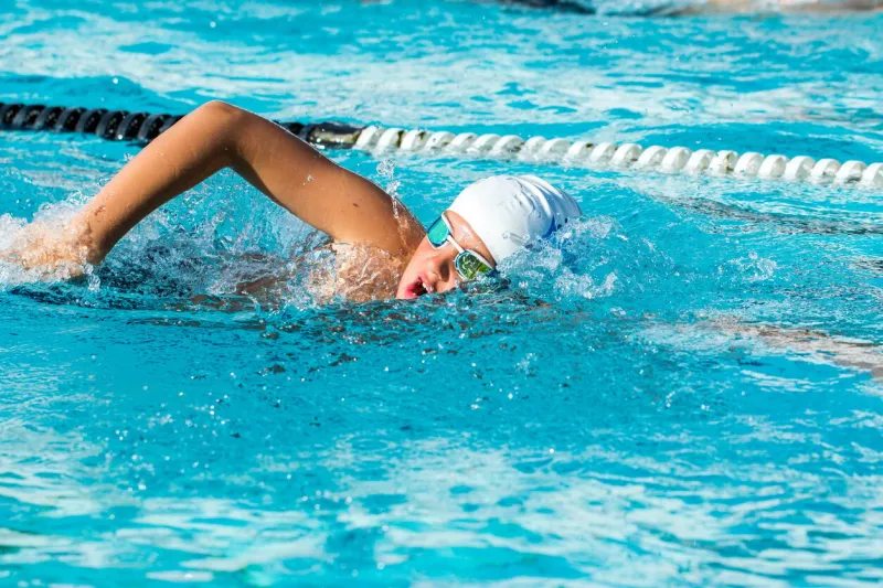 close up action shot of teen boy swimming freestyle at swimming lesson