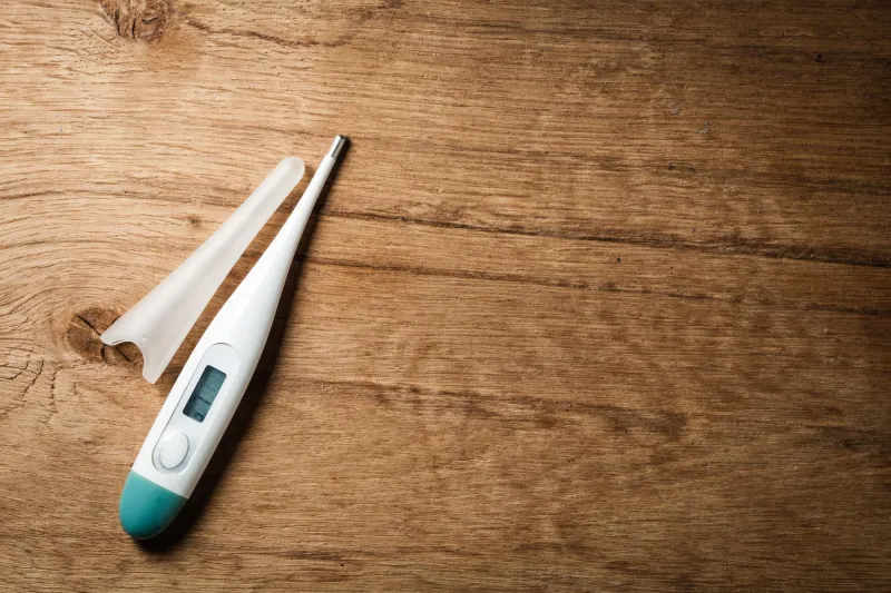 gros plan médical de thermomètre électronique sur la fièvre de fond en bois