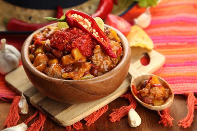 chili maïs carne - cuisine mexicaine traditionnelle, dans un bol en bois, sur serviette, sur fond de bois