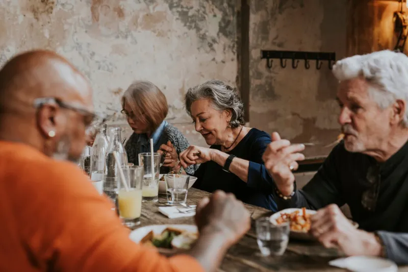 old friends eating dinner at restaurant