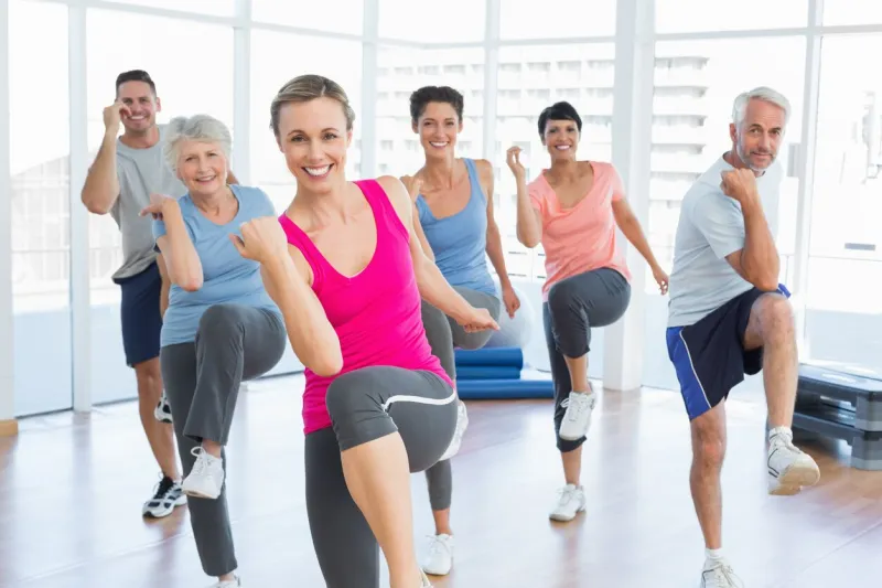 portrait of smiling people doing power fitness exercise at yoga class in fitness studio