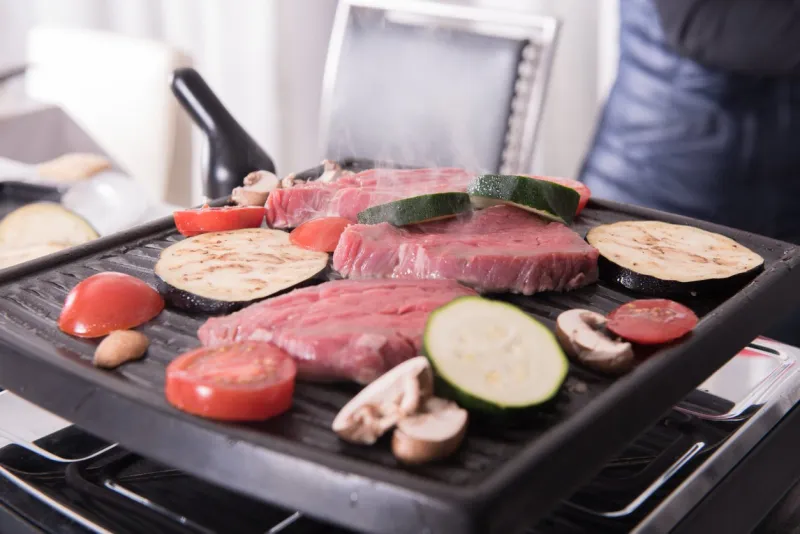 steaks and mushrooms on the raclette cooking