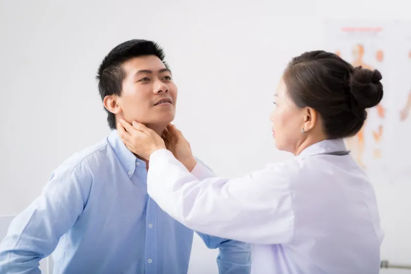 female doctor palpating lymph node of a young man