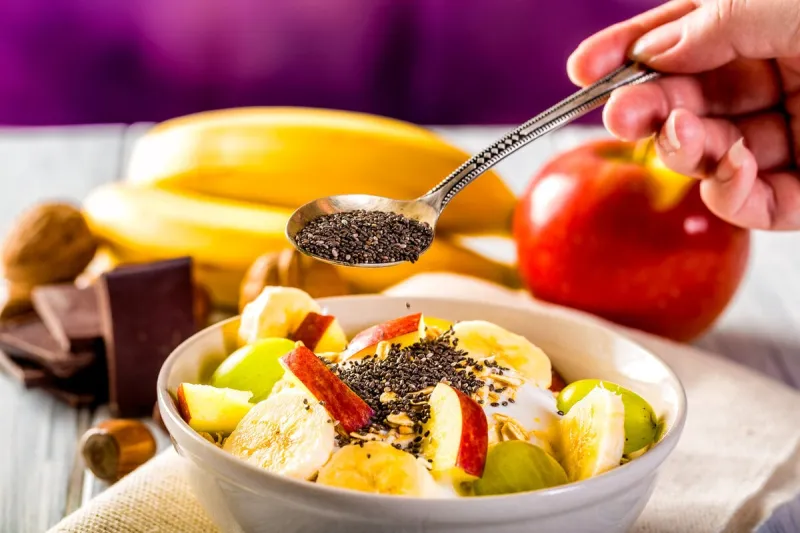 healthy breakfast with yogurt, apple, banana and chia seeds bowl of fresh fruit
