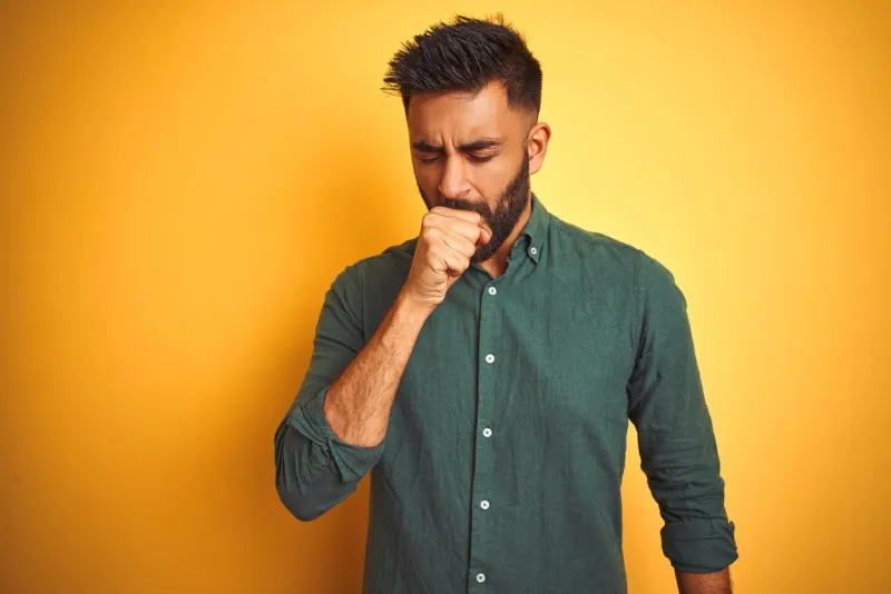 young indian businessman wearing elegant shirt standing over isolated white background feeling unwell and coughing as symptom for cold or bronchitis healthcare concept