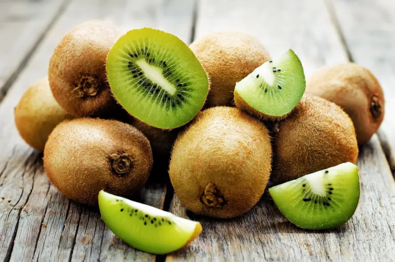 kiwi on white wood background tinting selective focus
