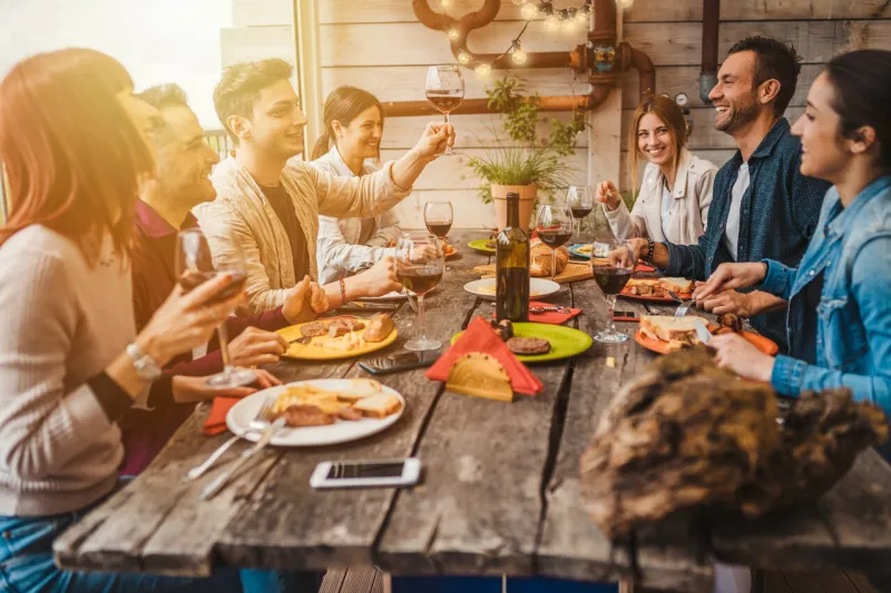 group of young people having lunch on a terrace of an apartment