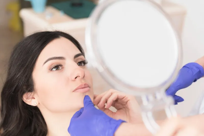 beautiful young woman having aesthetic treatment in medical office, corrective medicine concept