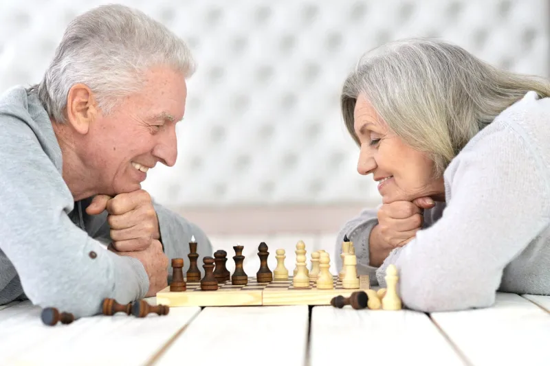 portrait of a happy senior couple playing chess