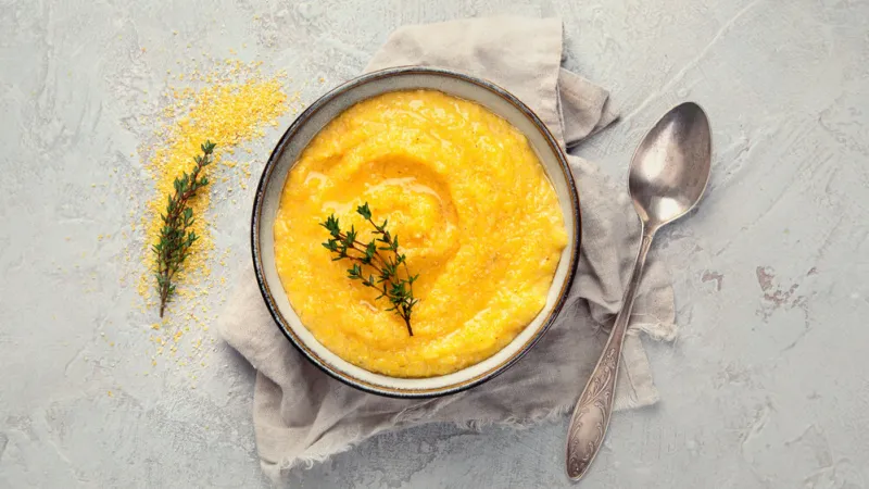 corn polenta on gray background healthy food concept top view, flat lay, copy space