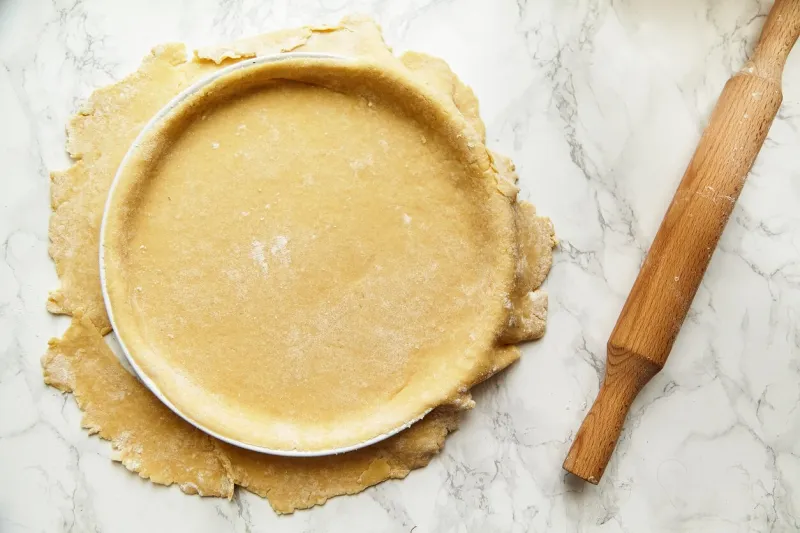 rolling a pastry for baking a pie and pricking it with fork recipe concept