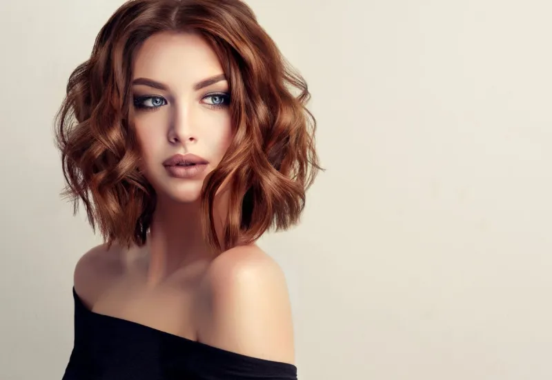 attractive brown haired woman with modern, trendy and elegant hairstyle example of middle length,dense and curly hairgentle make up and long eyelashes