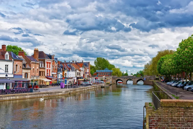 amiens, france - may 9, 2012  quay of belu with traditional houses and somme river in amiens, picardy, france people on the background