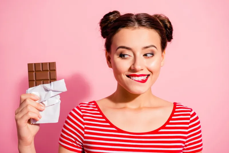 close-up portrait of nice cute charming attractive winsome glamorous cheerful girl wearing striped t-shirt holding in hands looking favorite dessert life lifestyle advert isolated on pink background
