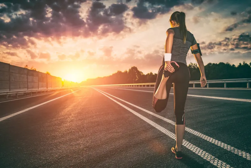 stretching run runner road jogging clothes flare sunset street fitness cross sunbeam success running sportswear - stock image