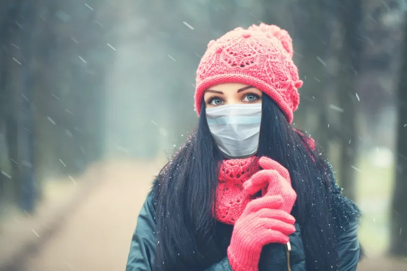 winter woman in medical protective face mask outdoors, winter portrait