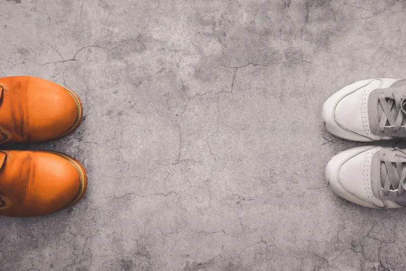 social distance top view of human shoes at a distance from each other on a gray concrete background compliance with a distance of 2 meters with copy space concept