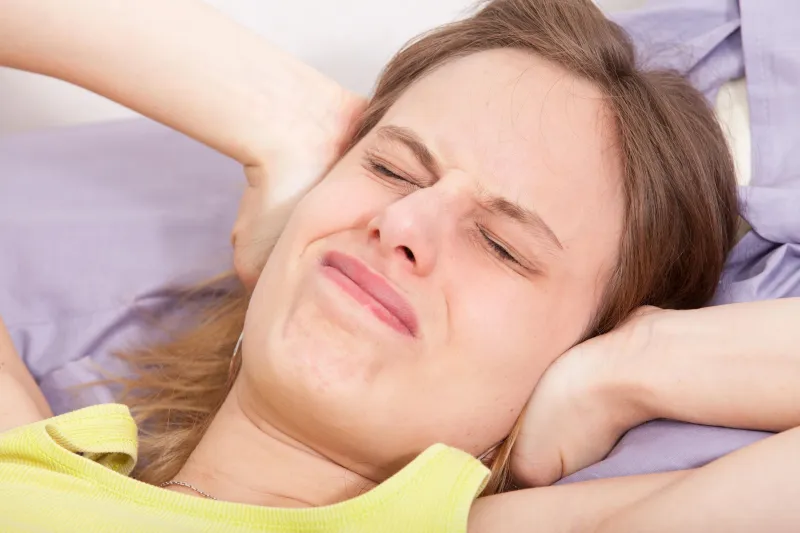 jeune femme caucasienne au lit avec la dépression de maux de tête