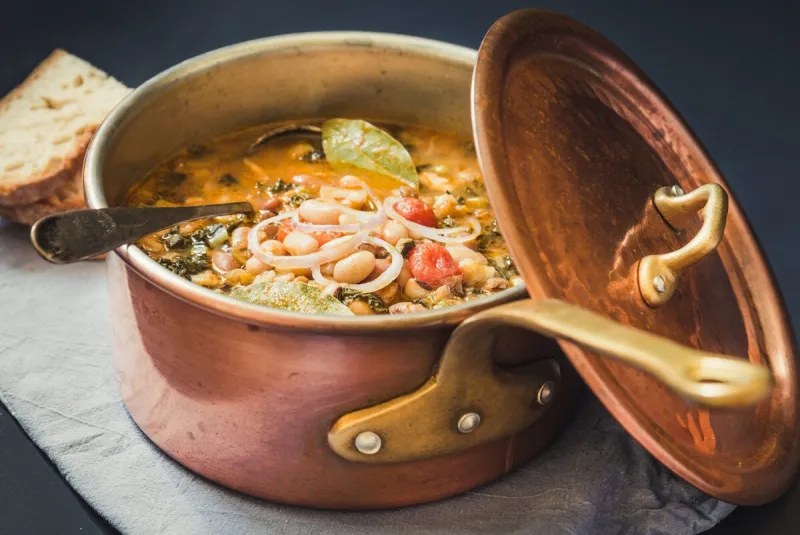 soup with different vegetables, cannellini beans, kale, breadtypical tuscan soup, ribollita in copper pot
