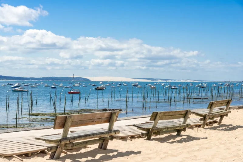 cap ferret (arcachon bay, france), bancs publics sur la plage de l'herbe face à la dune du pilat