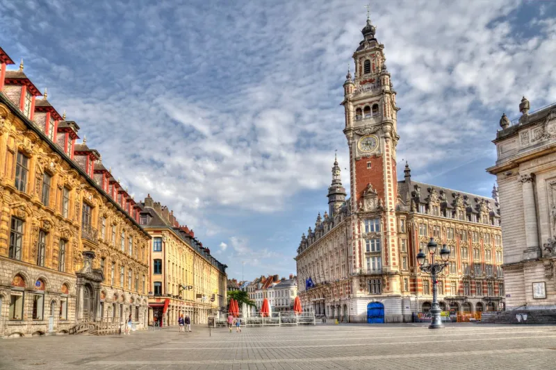 people walk on the place de theatre with the clock tower in the historical center of lille, france on may 27