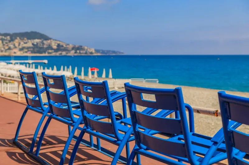 mediterranean sea and famous blue chais on promenade des anglais at sunset in nice, cote d'azur, france
