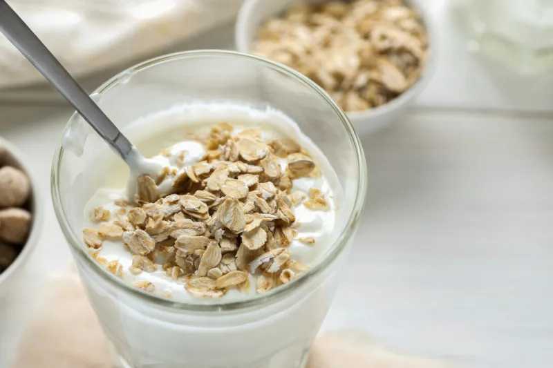 healthy breakfast, smoothie with oat flakes on a white wooden table