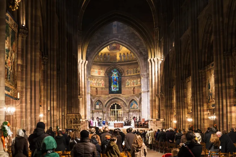 strasbourg, france - december 11, 2011  people on night church service in the cathedral of notre dame of strasbourg city (strassburger muenster) during christmas festive season