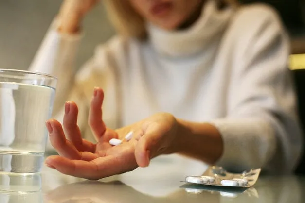 close up of woman hands holding a pills