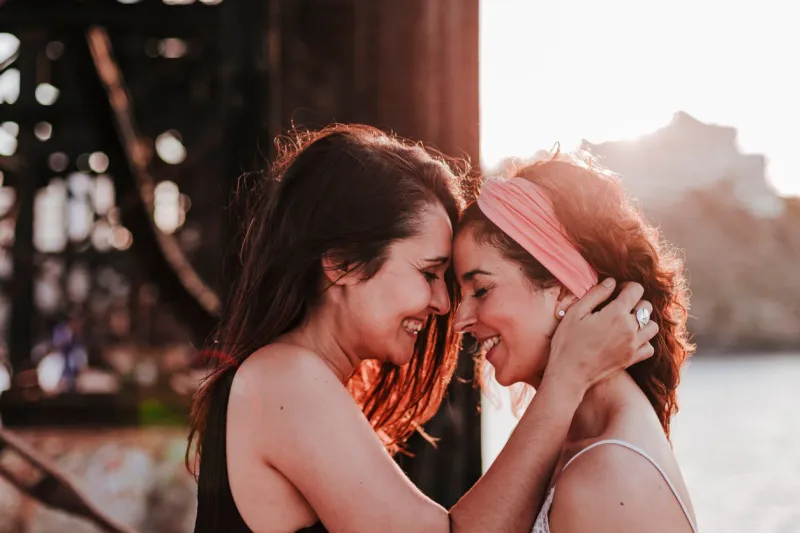 young lesbian couple hugging at sunset outdoors lifestyle and pride concept love is love