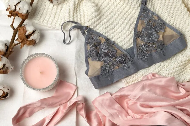 beauty, fashion, blogger concept - lace lingerie, dried cotton flower, silk, robe, candle on white bed background, social media, fashion accessories