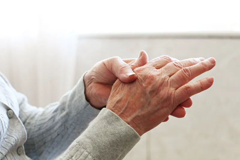 elderly woman applying moisturizing lotion cream on hand palm, easing aches senior old lady experiencing severe arthritis rheumatics pains, massaging, warming up arm close up, copy space, background