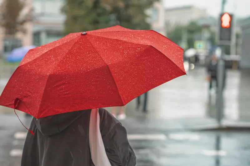 abstract girl under red umbrella, modern city at rainy evening