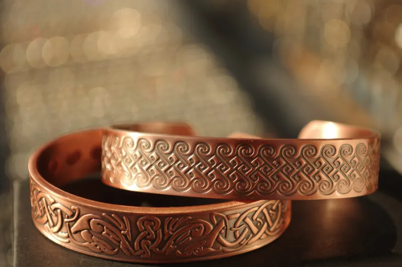 a closeup shot of copper bracelets with patterns