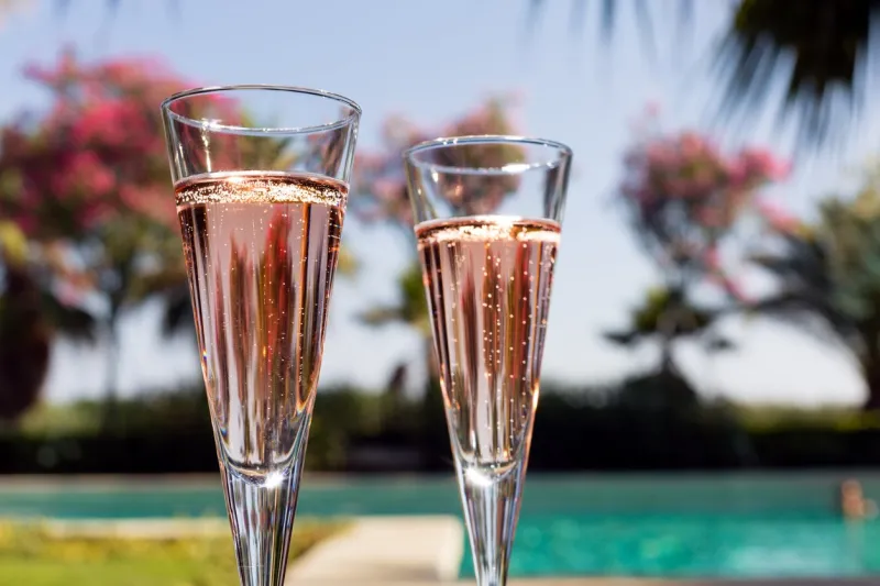 two glasses of champagne on the glass table in outdoor resort bar