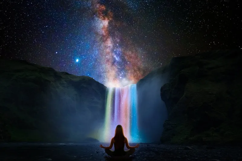 woman doing yoga in front of a magic waterfall