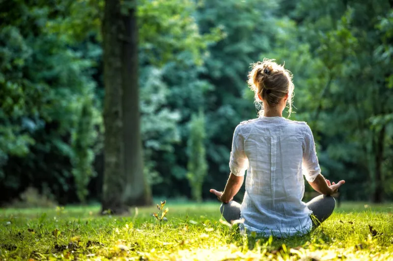 woman meditating and practicing yoga in forrest