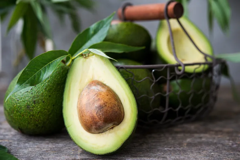 fresh green avocado on wooden background selective focus horiz