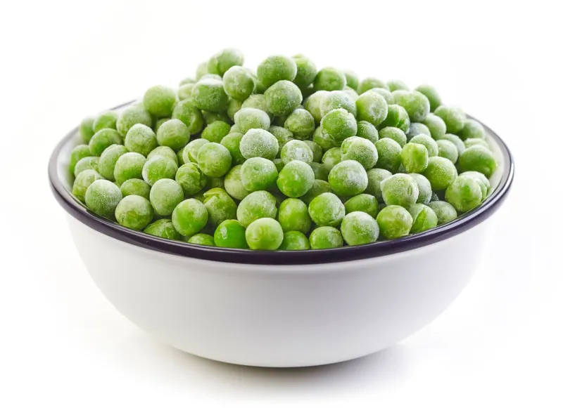 bowl of frozen green peas isolated on white background