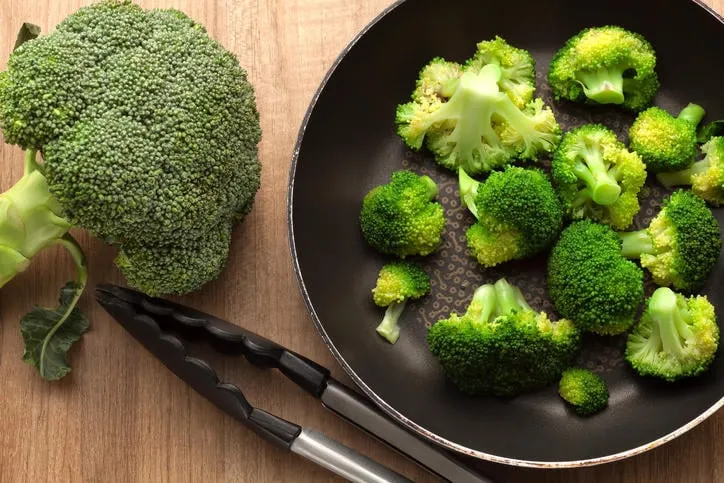 brocoli dans la casserole sur la table de cuisine en bois